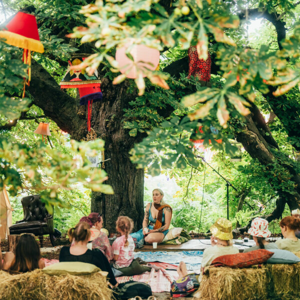 a group listening to a talk under a big tree