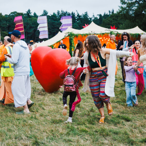 a woman and child dancing near a big red heart